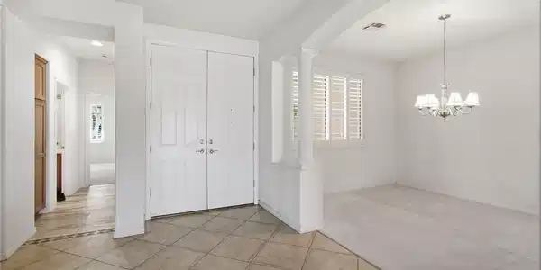Image 4: Double front doors open into a tiled entryway adja