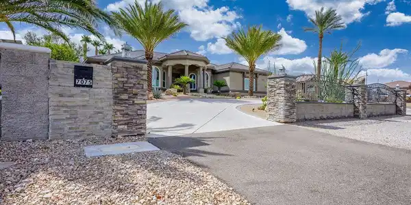 Image 4: Palm trees frame a sweeping paved driveway leading