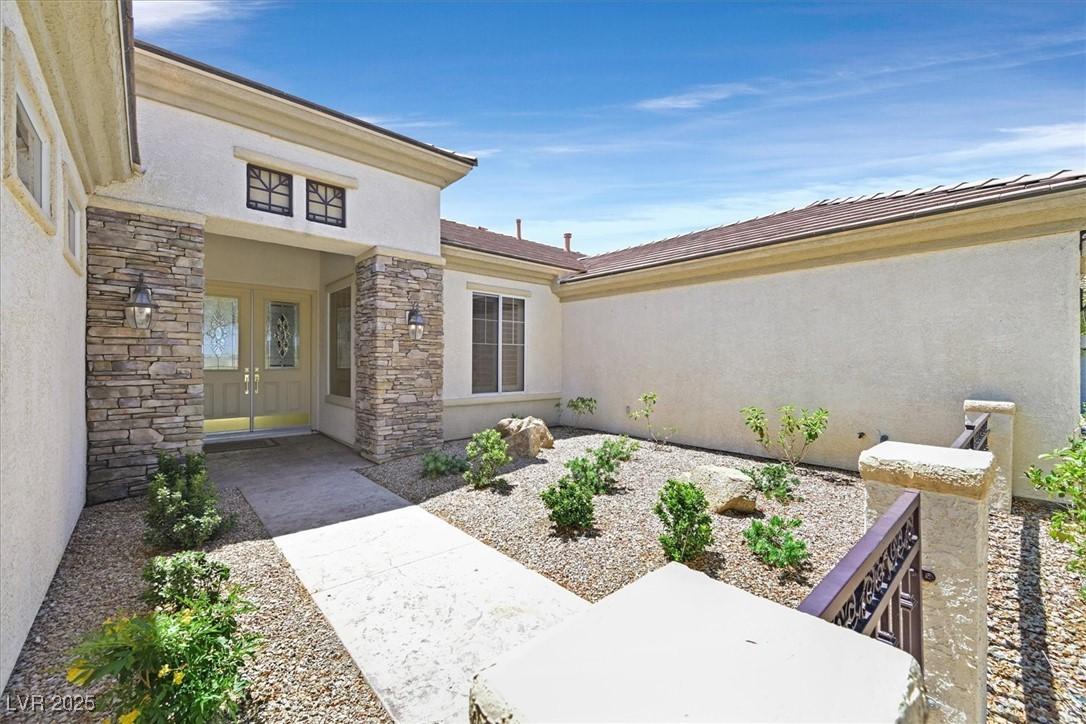 Image 3: Doorway to property with stucco siding and stone s