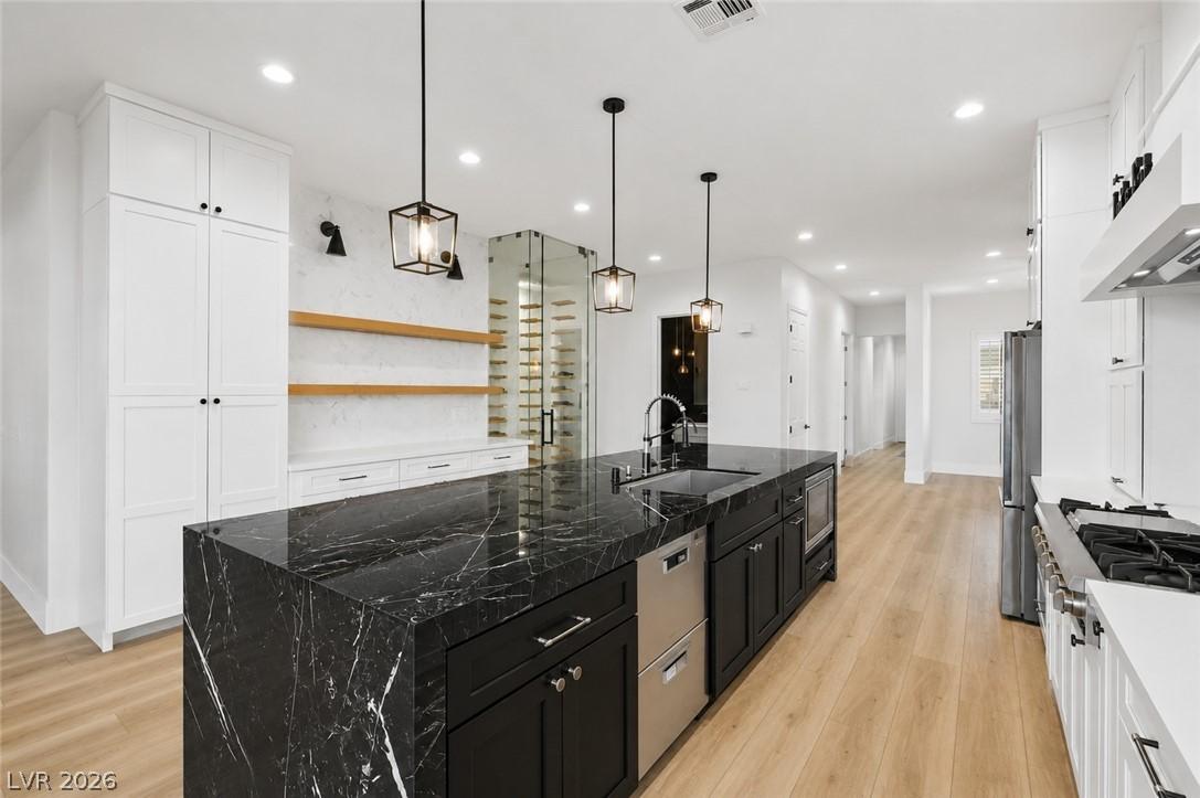 Image 4: A well-lit kitchen features a dramatic black marbl