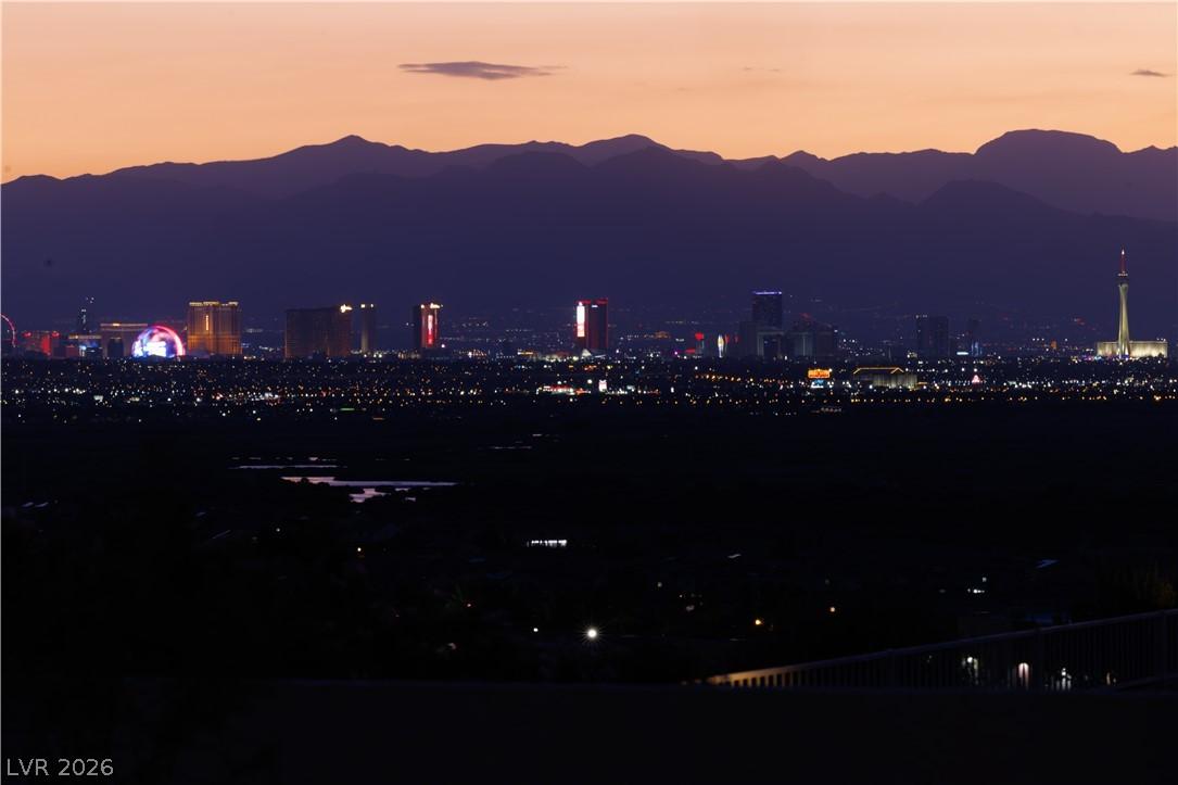 Image 4: City lights glitter against a mountainous backdrop