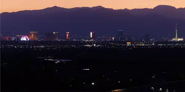 Image 4: City lights glitter against a mountainous backdrop