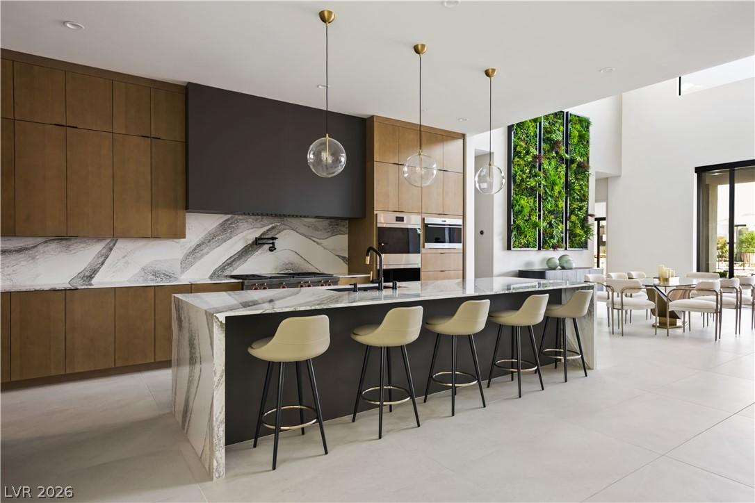 Image 2: Marble waterfall island with a sleek cooktop ancho