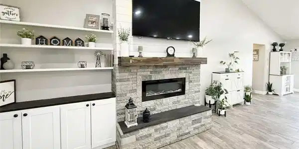Image 4: A striking stone-clad fireplace and built-in shelv