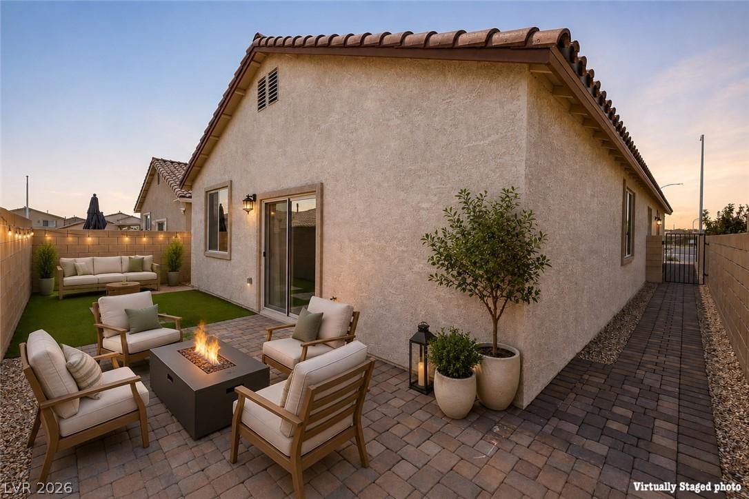 Image 3: An inviting backyard patio features a cozy fire pi