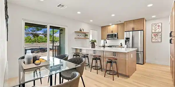 Image 3: A modern kitchen and dining area features sleek wo