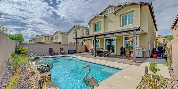Image 3: An inviting backyard oasis features a sparkling in