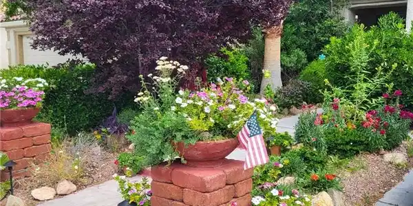Image 2: Lush landscaping and colorful plantings frame the