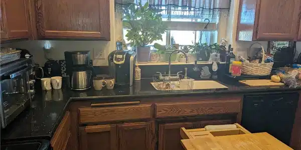 Image 4: A well-appointed kitchen features rich wood cabine