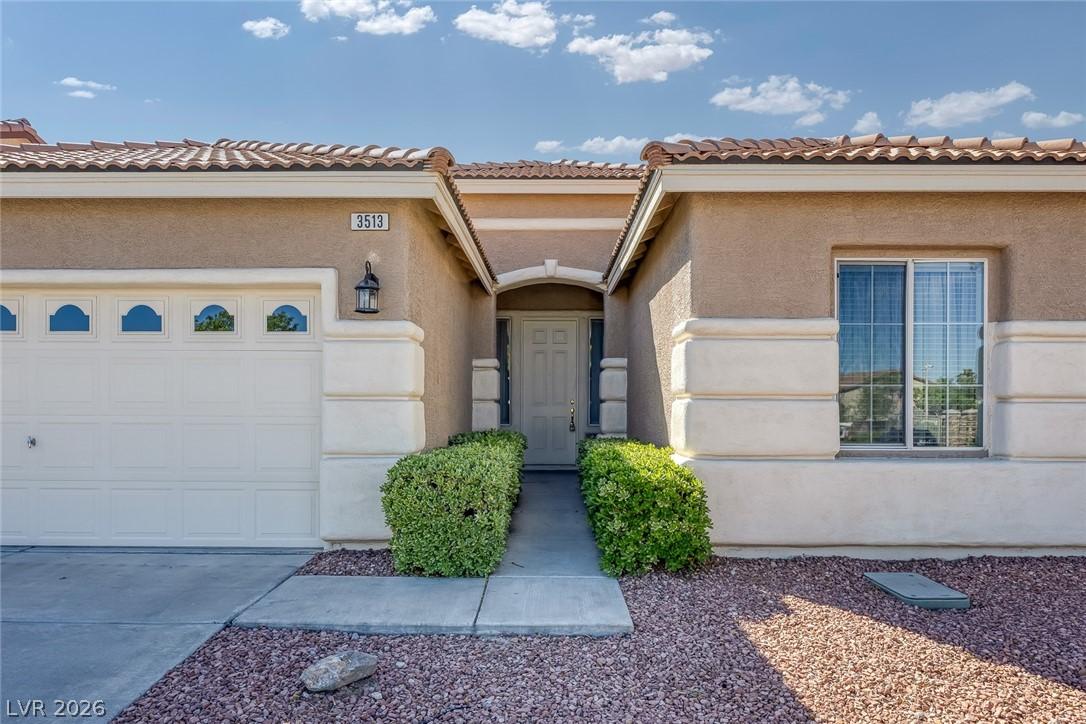 Image 3: Property entrance with a tiled roof, stucco siding