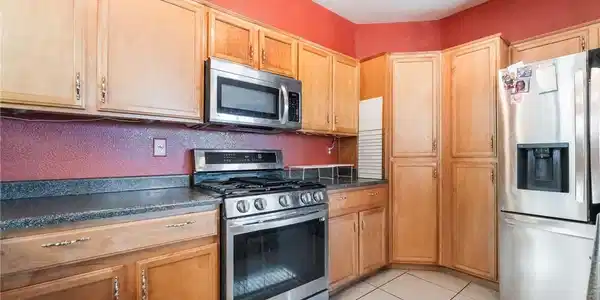 Image 4: A well-appointed kitchen features ample light wood