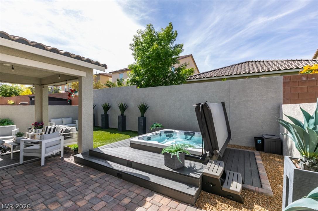 Image 4: An inviting backyard oasis offers a covered patio