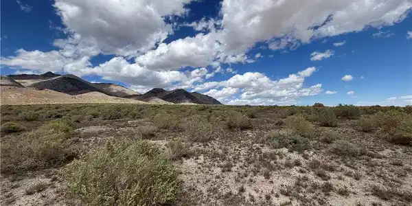 Image 3: Dramatic mountain peaks and native desert vegetati