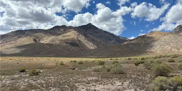 Image 4: Dramatic mountain peaks rise high above the natura