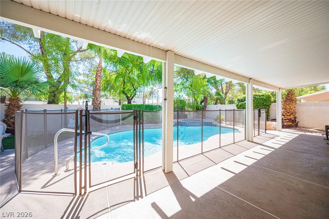 Image 2: An inviting covered patio overlooks a sparkling fe