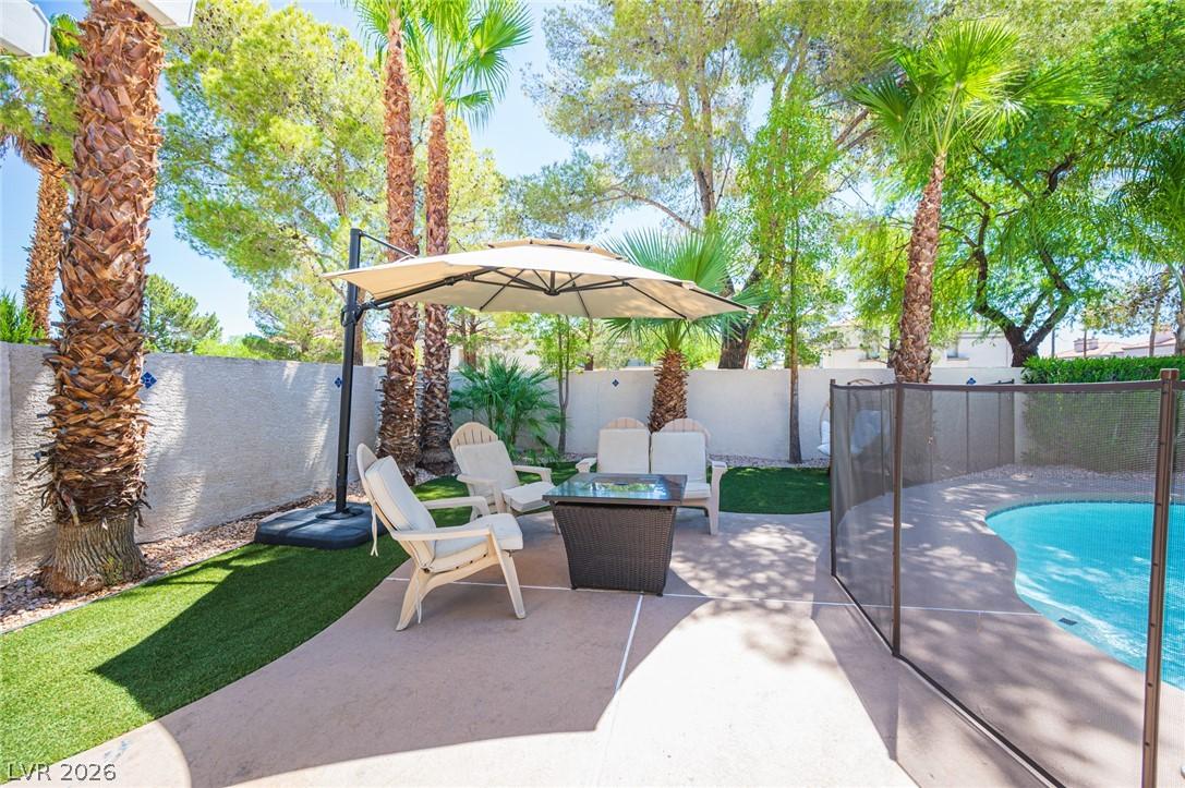Image 3: An inviting backyard oasis features a textured pat