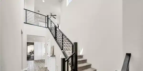 Image 4: A grand entryway features high ceilings, an elegan