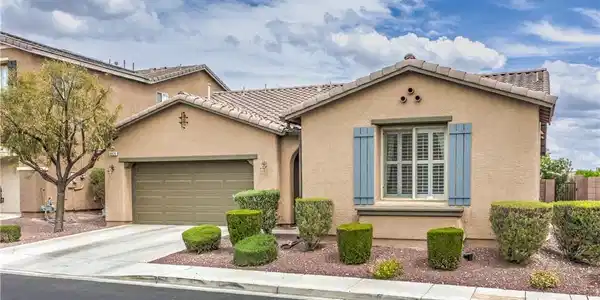 Image 2: A welcoming front exterior features a driveway and