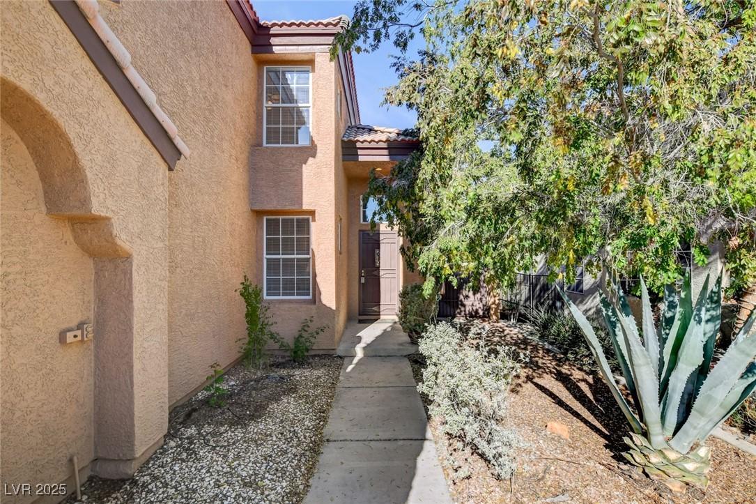Image 2: Property entrance featuring a tile roof and stucco