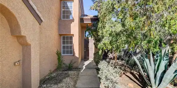Image 2: Property entrance featuring a tile roof and stucco