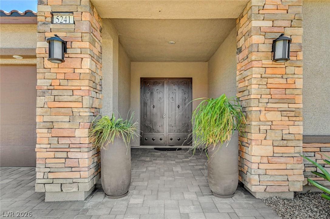 Image 4: A grand entry features stacked stone pillars frami
