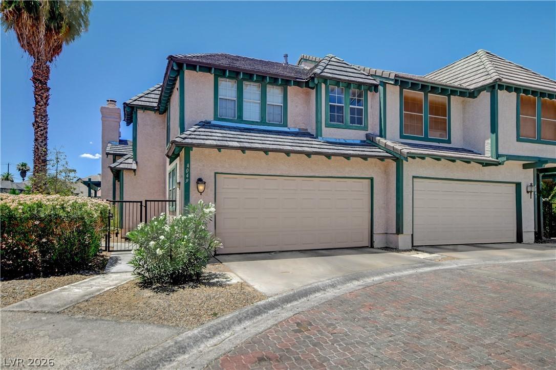 Image 2: A charming stucco exterior welcomes with a two-car