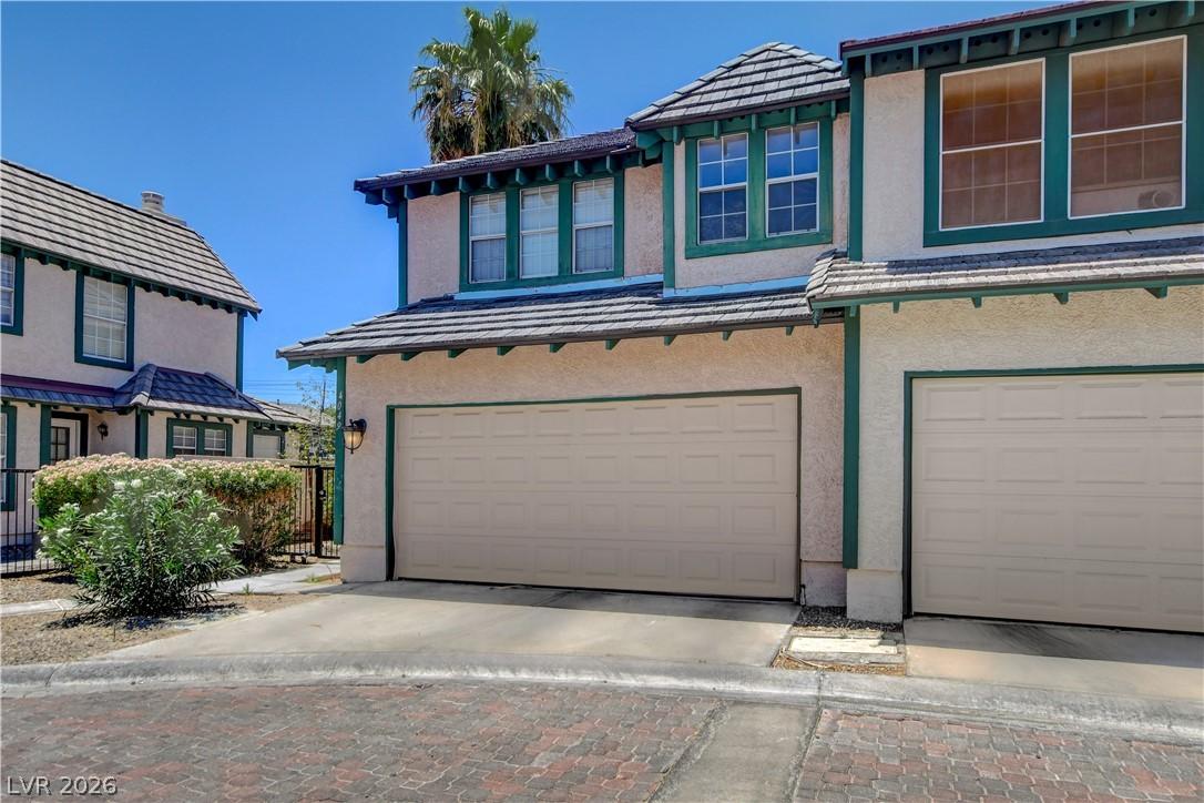 Image 3: A cream-colored stucco exterior with green trim of