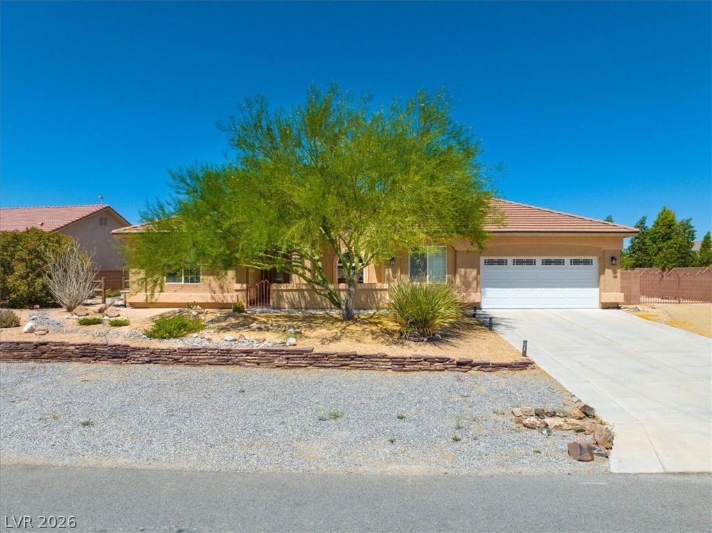 Image 1: A well-maintained stucco home with an attached gar