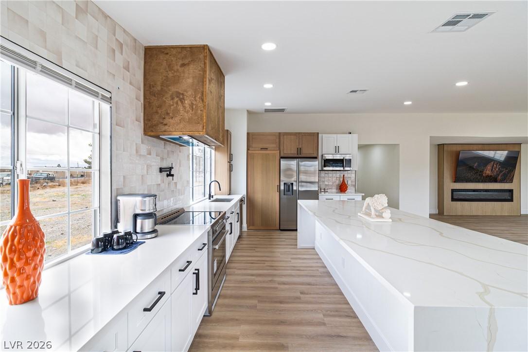 Image 1: Kitchen with tasteful backsplash, visible vents, a