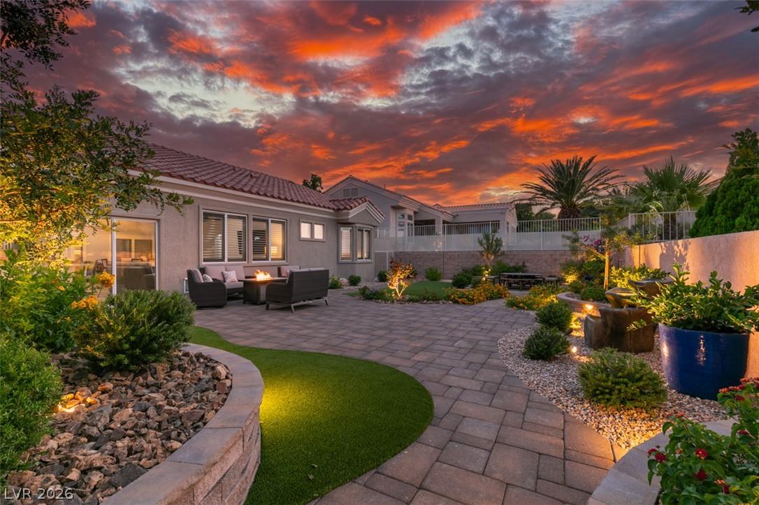 Image 1: A lavish paver patio with a fire pit invites eveni