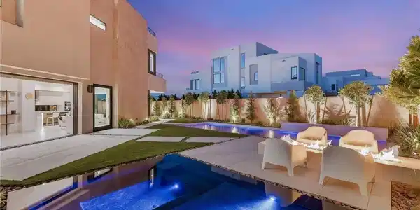 Image 3: A luxurious modern backyard oasis features a glist
