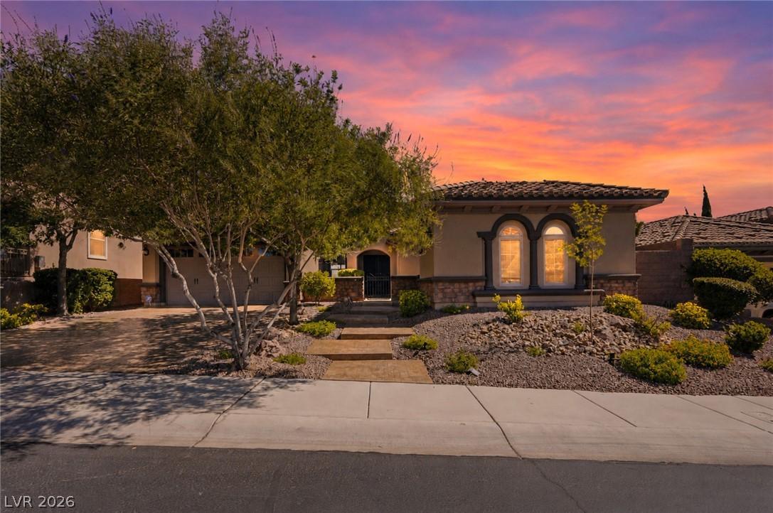 Image 2: An inviting front facade with lush landscaping and