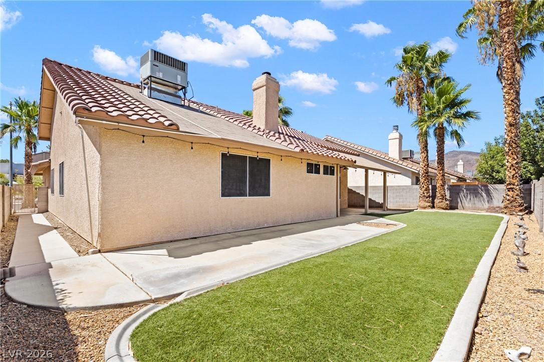 Image 4: Maintained artificial turf and a covered patio for
