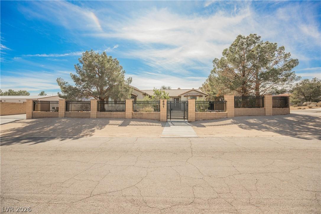 Image 1: Securely gated property offers a broad paved entra
