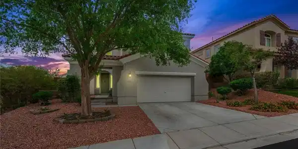 Image 2: Mature trees frame the inviting entryway of this c