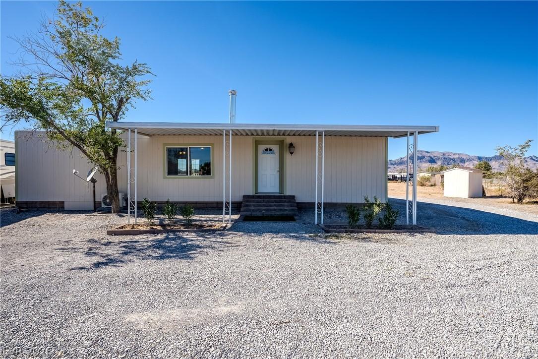 Image 3: A welcoming covered porch and gravel driveway defi