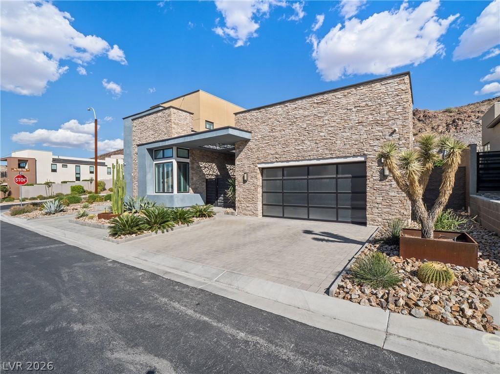 Image 3: Modern desert home featuring a stone facade and a