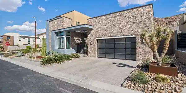 Image 3: Modern desert home featuring a stone facade and a