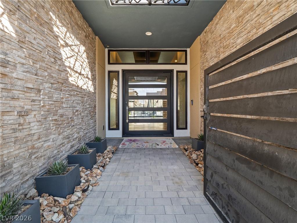 Image 4: An inviting entrance with stone veneer walls and a