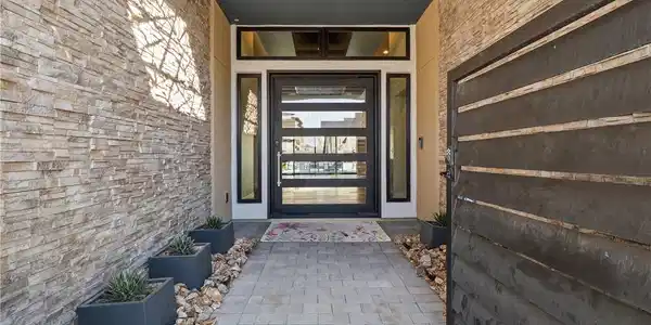 Image 4: An inviting entrance with stone veneer walls and a