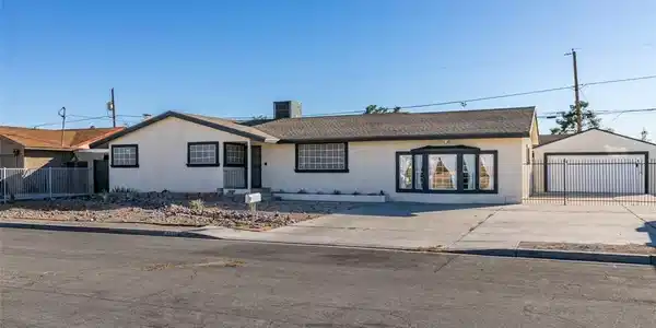 Image 2: A classic ranch home features a neatly paved drive