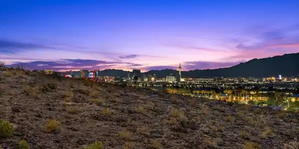 Image 3: City lights twinkle against a mountain backdrop as