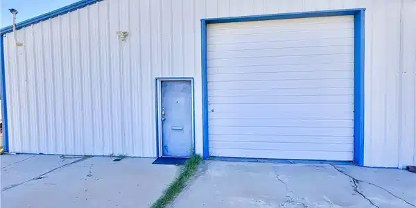 Image 4: A utilitarian structure with a large garage door a