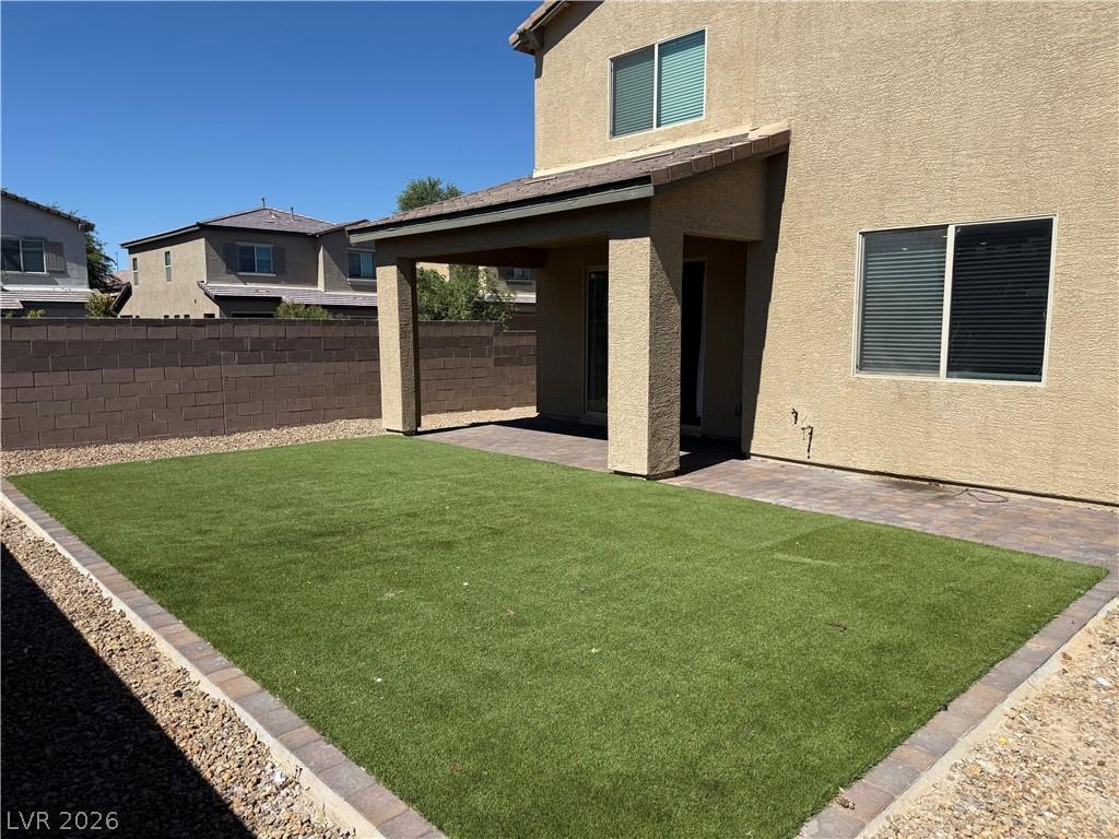 Image 2: A private yard with a covered patio and maintenanc