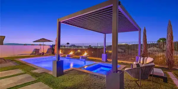 Image 2: A modern pergola overlooks the inviting pool and s