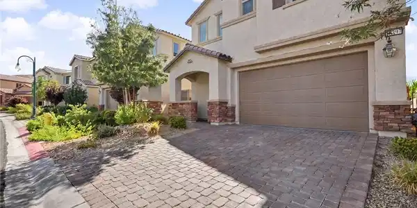 Image 3: Stone accents and a paved driveway enhance the ext