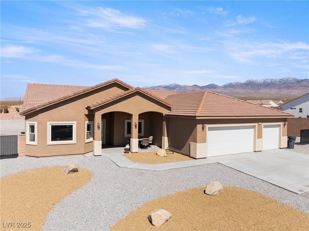 Image 2: Single story home with stucco siding, driveway, a