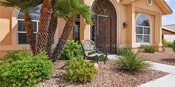 Image 4: An arched entry with ornate ironwork highlights th