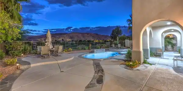 Image 4: A spacious concrete patio frames an inviting swimm