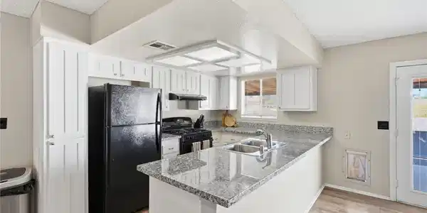 Image 4: Granite counters and light-toned flooring define t